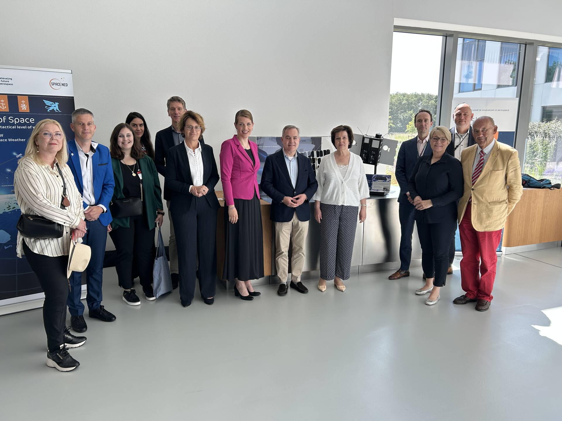 De delegaties van de Eerste Kamer en het Nederlands Lucht- en Ruimtevaartcentrum voor een ruimtevaartstand